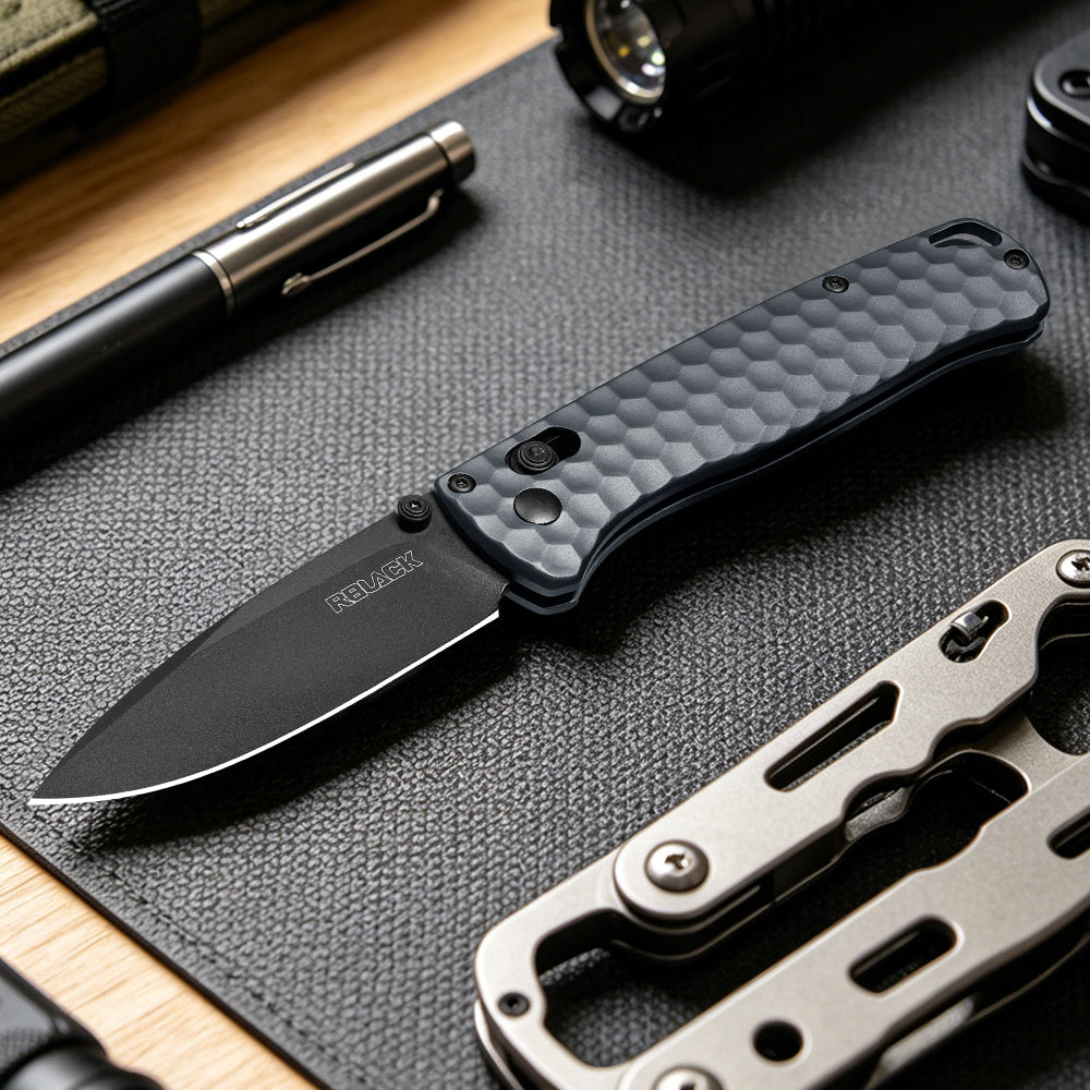 RBLACK S35VN Folding knife with textured handle on a dark surface with another knife and pen in the background.
