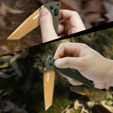 Close-up of a hand holding a folding knife with a green handle and orange blade, against a natural background. RBLACK crossbar lock detail on blue G10 tanto folding knife