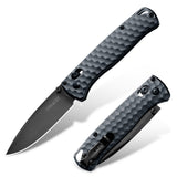 A folding EDC pocket knife shown open and closed on a clean white background. The knife features a textured black handle with a aluminun fiber honeycomb pattern and a matte black drop-point blade.