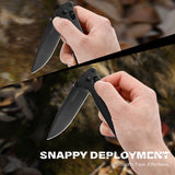 Person holding a folding knife with 'Snappy Deployment' text overlay on a natural background.